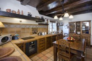 une grande cuisine avec des placards en bois, une table et des chaises dans l'établissement Casa Perdomo, à Masdache