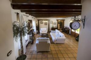 a living room with two white couches and a clock at Casa Perdomo in Masdache