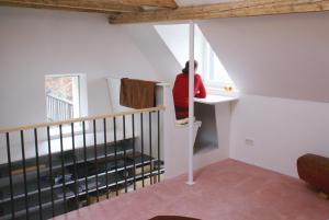 eine Person auf einem Schreibtisch in einem Zimmer mit einer Treppe in der Unterkunft Logenplatz über Trier in Trier