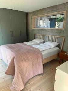 a bedroom with a bed with a pink blanket on it at House in Lofoten, beautiful view/ Hus i Lofoten in Kabelvåg