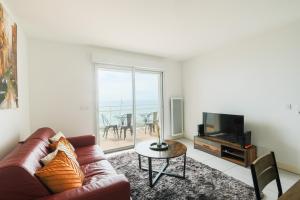 a living room with a couch and a television at Appartement - vue exceptionnelle in Lacanau-Océan