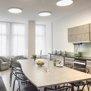 a kitchen with a large wooden table and chairs at Riess City Rooms - Self Check-in in Vienna