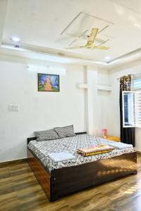łóżko w pokoju z krzyżem na suficie w obiekcie Pitambara Dham w mieście Wryndawan