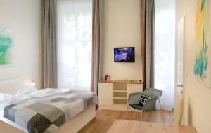 um quarto com uma cama, uma cadeira e uma janela em Riess City Rooms - Self Check-in em Viena