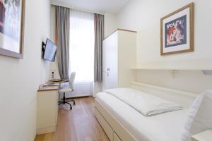 1 dormitorio con 1 cama y escritorio con ordenador en Riess City Rooms - Self Check-in, en Viena