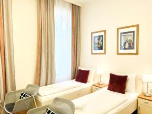 ein Hotelzimmer mit 2 Betten und einem Fenster in der Unterkunft Riess City Rooms - Self Check-in in Wien