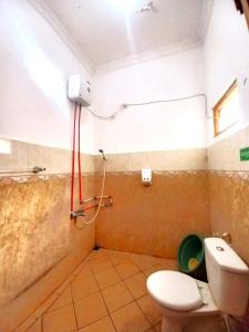 a small bathroom with a toilet and a shower at Homestay Jogja Samirono Dekat UNY by Simply Homy in Yogyakarta