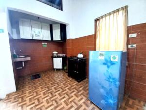 a kitchen with a refrigerator in the middle of a room at Homestay Jogja Samirono Dekat UNY by Simply Homy in Yogyakarta