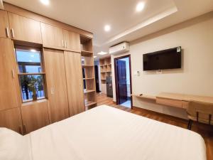 a bedroom with a bed and a flat screen tv at Mother's Home in Ho Chi Minh City