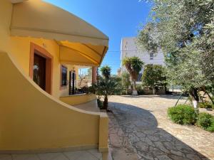 a yellow building with a sidewalk next to a street at Zak's Apartments in Ksamil