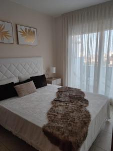 a bedroom with a large bed with a large window at Magnifico Adosado Villamar (Peñiscola) in Peniscola