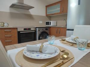 a kitchen with a table with plates and utensils at Magnifico Adosado Villamar (Peñiscola) in Peñíscola