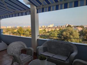 2 sillas en un balcón con vistas a la ciudad en Magnifico Adosado Villamar (Peñiscola), en Peñíscola