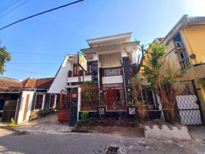 une maison avec une clôture devant elle dans l'établissement Homestay Jogja Samirono Dekat UNY by Simply Homy, à Yogyakarta