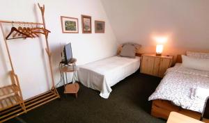 1 dormitorio con 2 camas y TV. en Am Elbradweg - Nichtraucher-Gästezimmer Weiland en Dresden