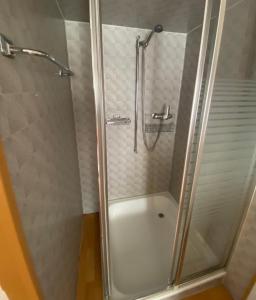 a shower with a glass door in a bathroom at Bom descanso in Ennenda