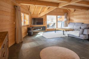ラルプ・デュエズにあるAlpe d'Huez Houses - Chalet Gustave - Beau chalet 4 chambres 50m piste Huez Expressのソファとテレビのあるリビングルーム