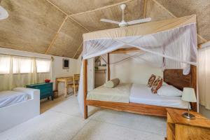 a bedroom with two bunk beds and a table at Cinnamon Hotel in Jambiani