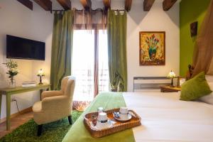 Habitación de hotel con cama, silla y TV en Posada de Eufrasio en Lerma