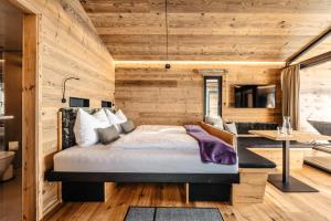 ein Schlafzimmer mit einem Bett und einem Schreibtisch in einem Zimmer in der Unterkunft Brandlalm Tinys in Gundisch