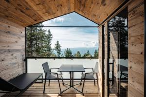 een kamer met een tafel en stoelen op een balkon bij Brandlalm Tinys in Gundisch