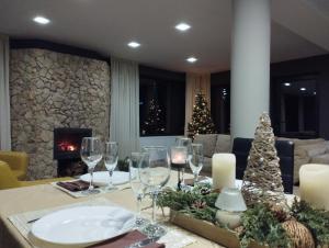 a dining room table with wine glasses and a christmas tree at Vila Gosen in Şard