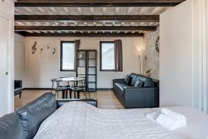 um quarto com uma cama, um sofá e uma mesa em Loft Santa Chiara - Affitti Brevi Italia em Lucca