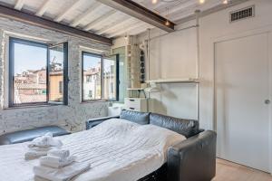 um quarto com uma cama num quarto com janelas em Loft Santa Chiara - Affitti Brevi Italia em Lucca