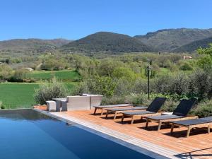 a pool with two lounge chairs on a wooden deck at Casale Alessandri in Massa Martana