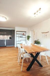 a dining room with a wooden table and white chairs at Wohnung 2 in Hagermarsch