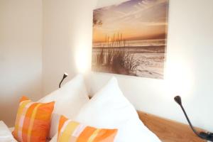 a painting hangs above a bed with pillows at Wohnung 3 - b43246 in Hagermarsch