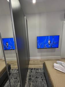 una camera con due letti e una TV a parete di 2 Room Suite Monte Nero- Best price vs quality-Fully equipped & renovated- City Centre a Olbia