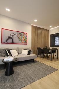 un soggiorno con divano e tavolo di 2 Room Suite Monte Nero- Best price vs quality-Fully equipped & renovated- City Centre a Olbia
