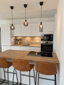 a kitchen with a wooden counter top with three chairs at Gîte le 9 bis Kervadail in Baden