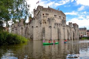 a group of people in kayaks in front of a castle at Hostel Uppelink in Ghent