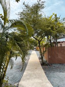 a pathway with trees and a fence in a yard at Dara Homestay in Ko Kood