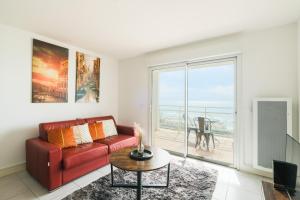 uma sala de estar com um sofá vermelho e uma mesa em Appartement - vue exceptionnelle em Lacanau-Océan