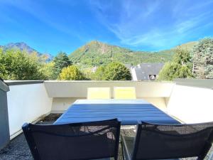 een blauwe tafel en 2 stoelen op een balkon bij appartement 6/7 personnes in Saint-Lary-Soulan