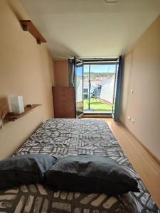 una camera da letto con un grande letto con una grande finestra di Ático Duplex CALLE MAYOR a El Burgo de Osma