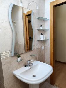 ein Bad mit einem Waschbecken und einem Spiegel in der Unterkunft Ático Duplex CALLE MAYOR in El Burgo de Osma-Ciudad de Osma