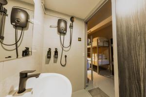 La salle de bains est pourvue d'un lavabo et d'un téléphone mural. dans l'établissement D'Nova Hotel Kallang, à Singapour