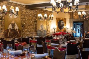Posada de Eufrasio في ليرما: غرفة طعام بها طاولات وكراسي وثريا