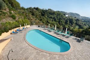 拉斯佩齊亞的住宿－gli ulivi di montalbano 1，一个带椅子和山脉的大型游泳池