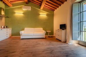 salon z białą kanapą i telewizorem w obiekcie Podere La Doccia w mieście Civitella in Val di Chiana