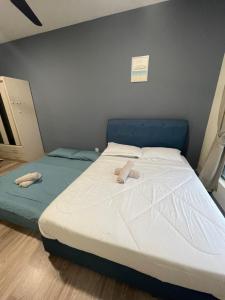 une chambre avec un grand lit et une tête de lit bleue dans l'établissement 8 Pax Family 100Mbps Kepong DesaPark MontKiara Publika Mitec, à Kuala Lumpur