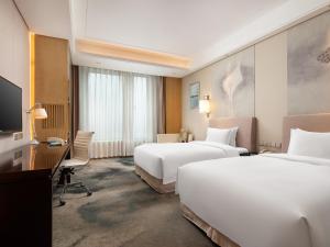 A bed or beds in a room at Yun Hotel Wuhan