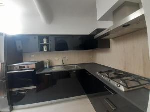 una cucina con lavandino e piano cottura di Le Stanze del Corso ad Ascoli Piceno