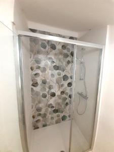 kabinę prysznicową ze wzorem kwiatowym na ścianie w obiekcie Le Stanze del Corso w mieście Ascoli Piceno