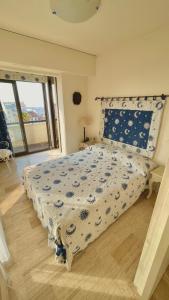 a bedroom with a bed with a blue and white comforter at Luxurious two-bedroom in Cannes