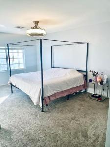 ein Schlafzimmer mit einem Himmelbett in einem Zimmer in der Unterkunft Gorgeous Serene Gated Newly Remodeled Townhouse in Las Vegas
